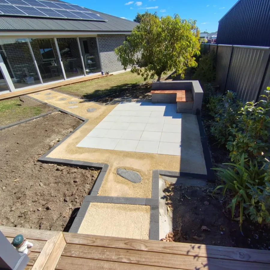 Paved patio with garden edging and seating wall